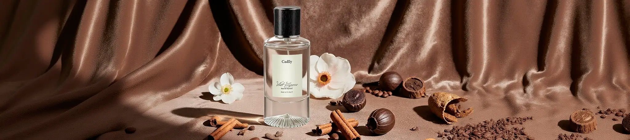 CADLLY perfume bottle with flowers and spices on a brown fabric background